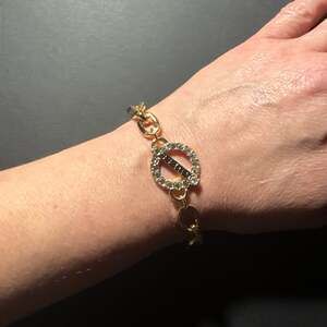 GUESS Gold Tone Charm Bracelet with Crystal Accents and Logo Charms